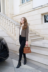 a lady in a white shirt, a brown wool jacket and a pair of black fitted pants